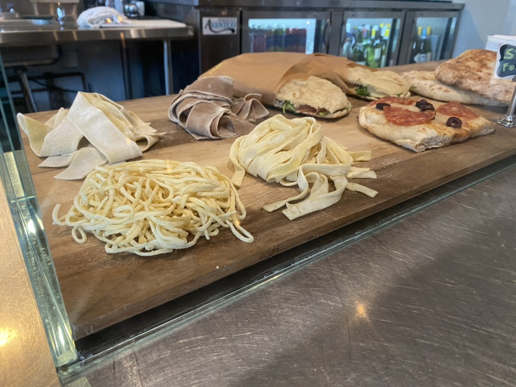 Fresh cut pasta on a wooden board in the case