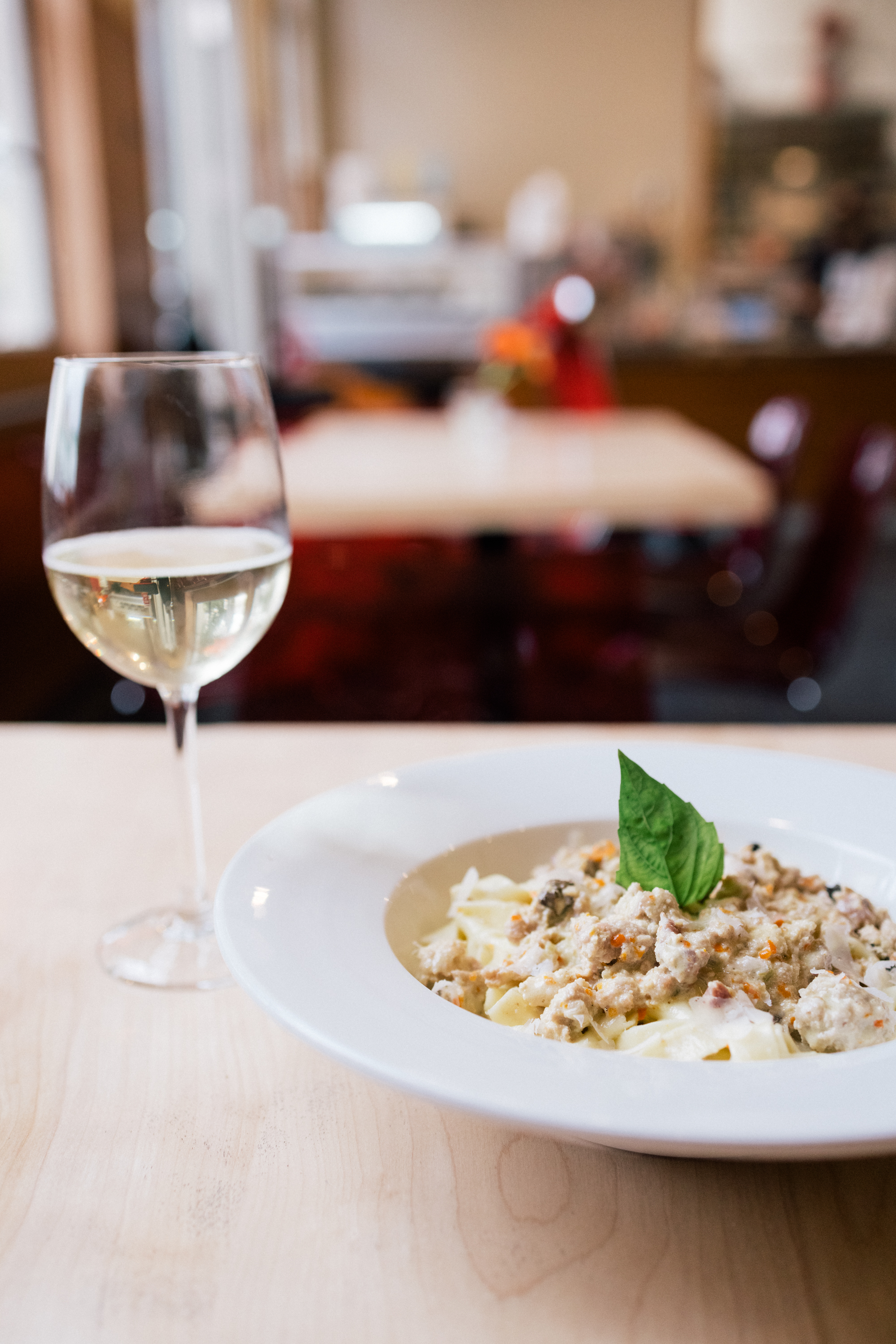 Tagliatelle with ragù and a glass of white wine