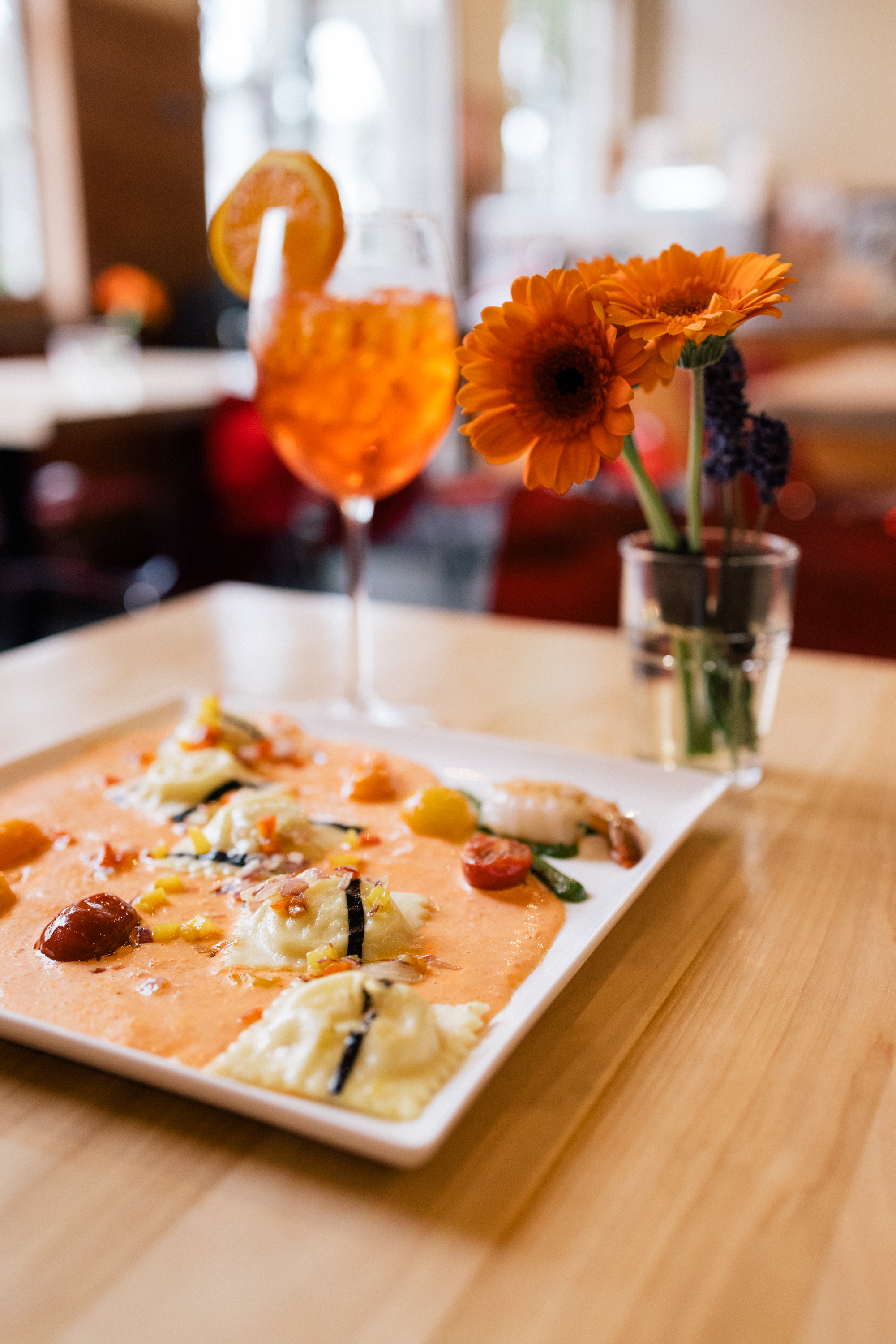 Ravioli in tomato cream with a spritz at Passione Emporio