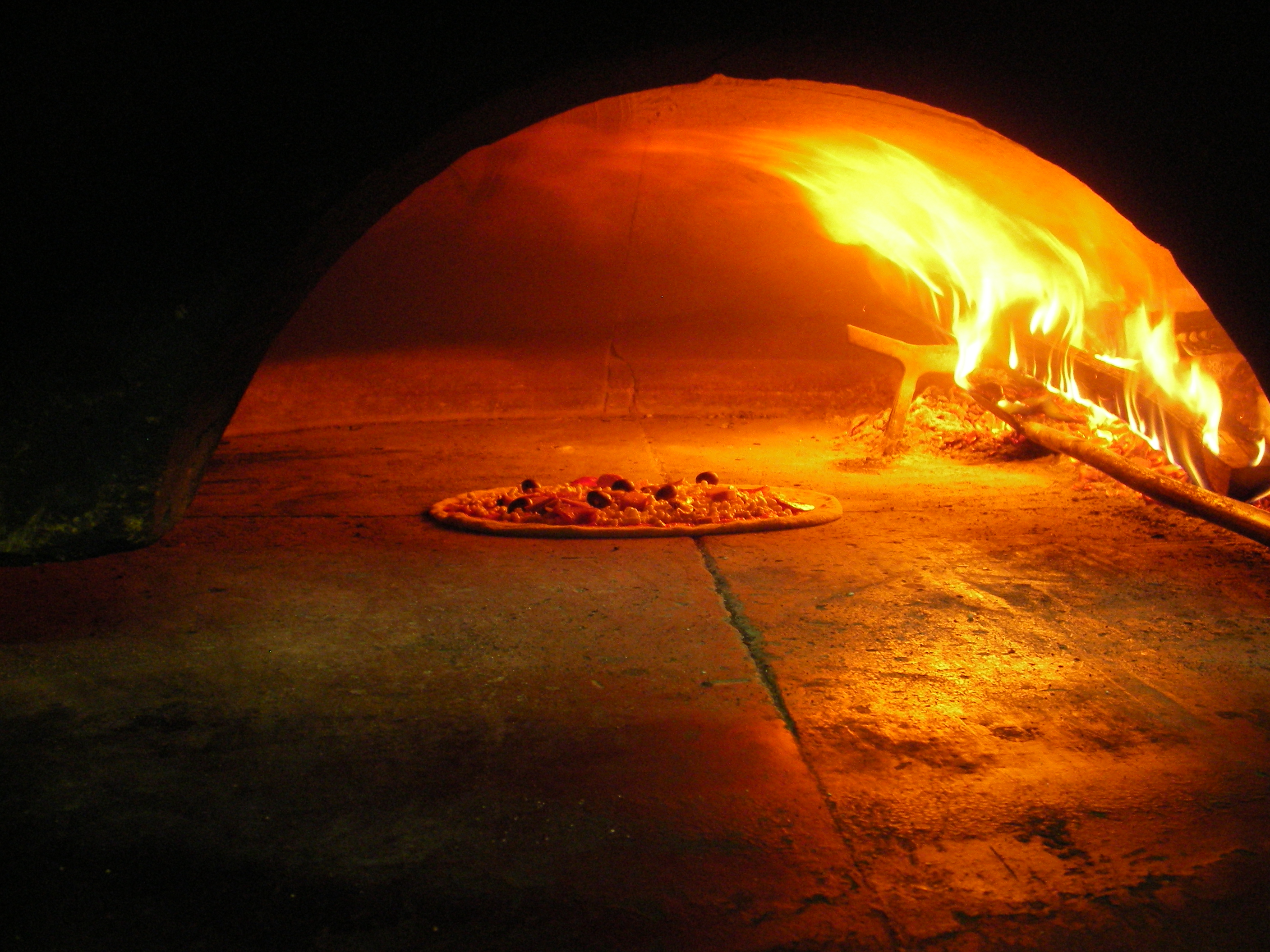 Pizza baking in the wood-fired oven