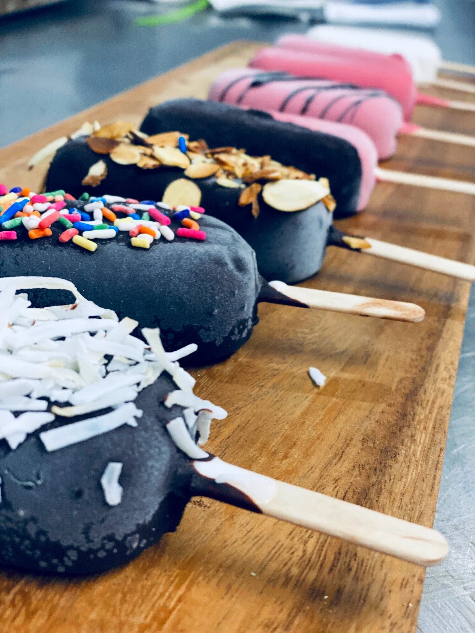 Chocolate-dipped gelato bars on a wooden board